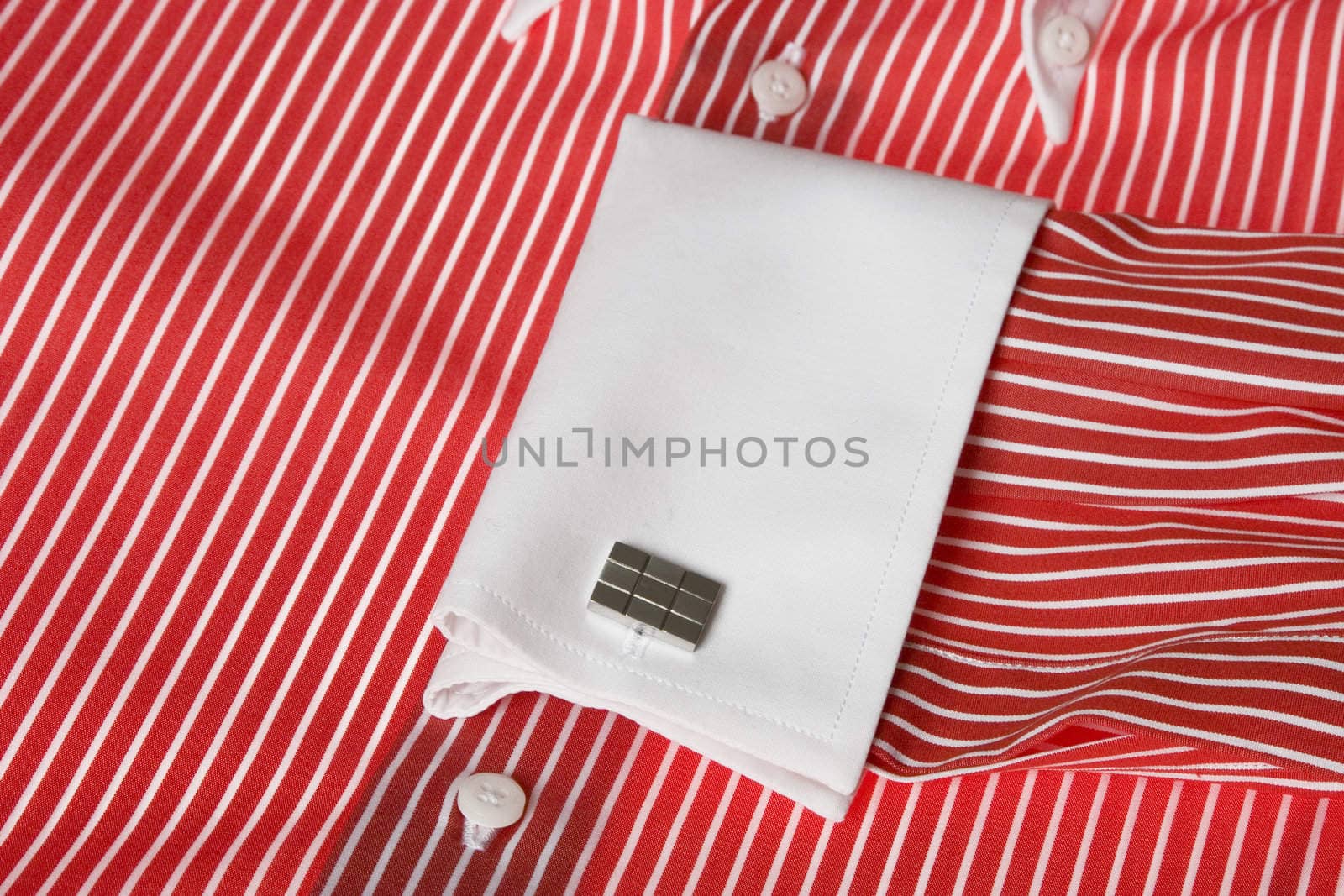 Close-up of cuff link on men's red shirt 