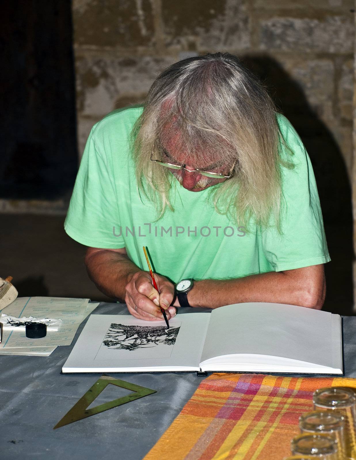 An artist busy at work concentrating on a drawing