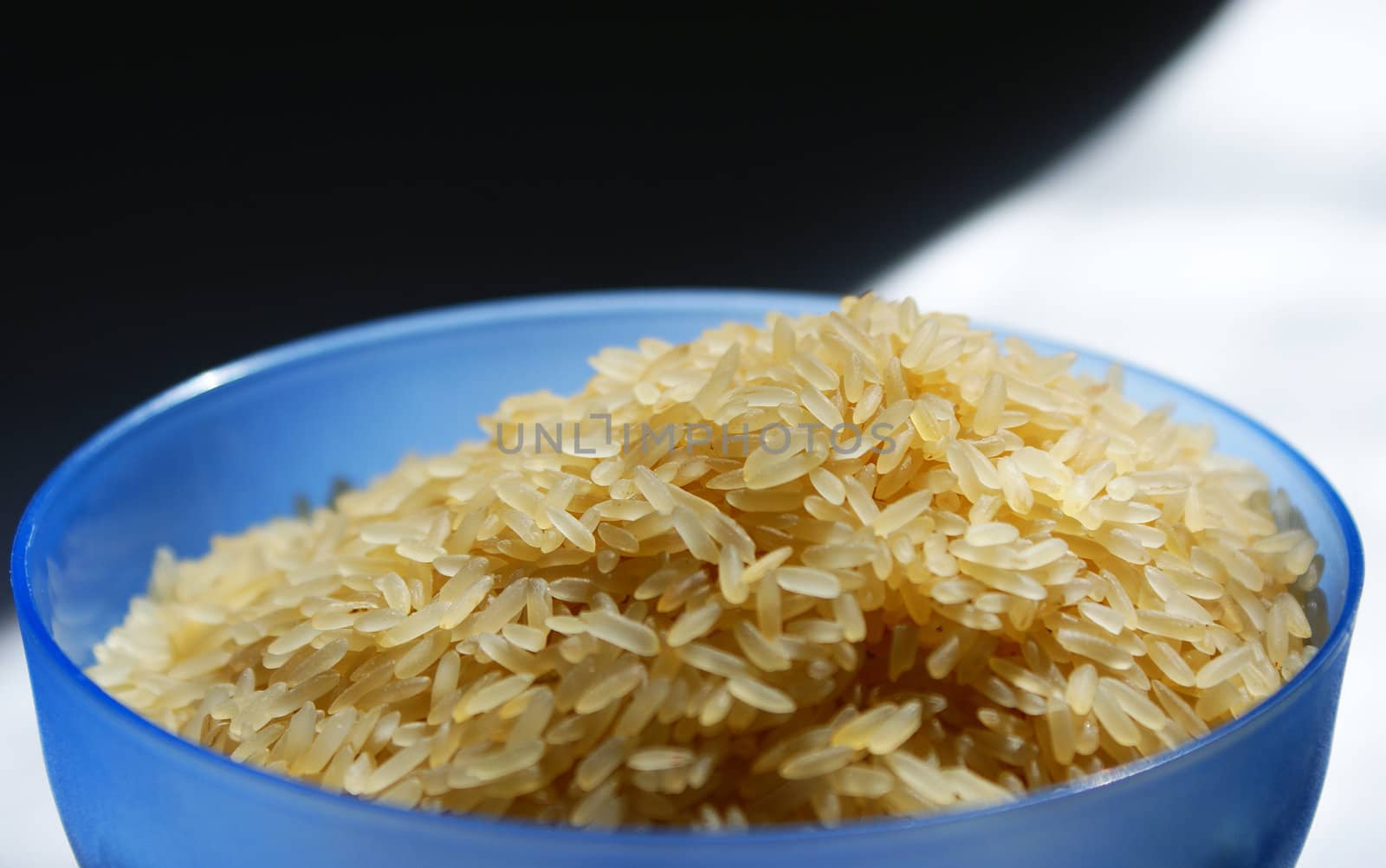 blue saucer with raw rice against black and white background