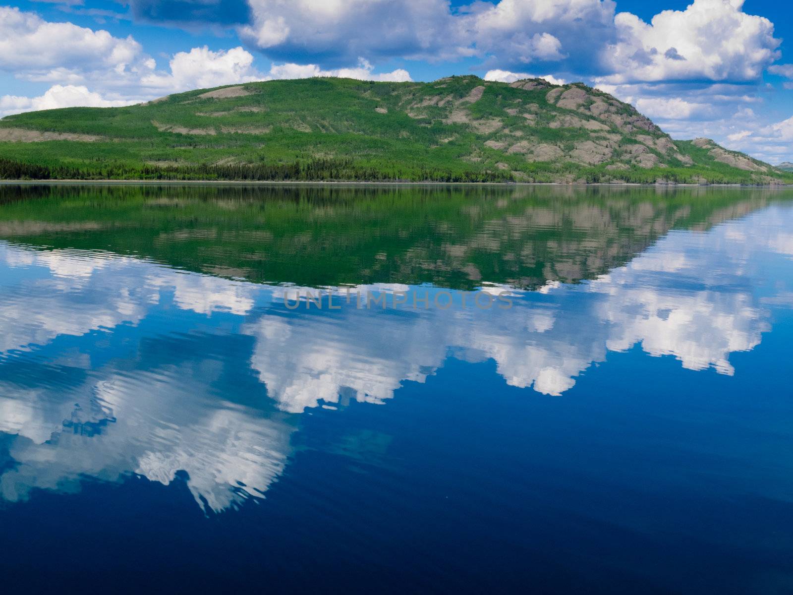 Yukon wilderness reflected on calm lake by PiLens
