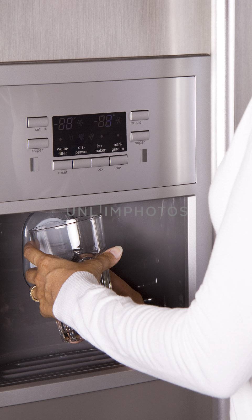 Close-up of a person getting water and ice from a modern refrigerator