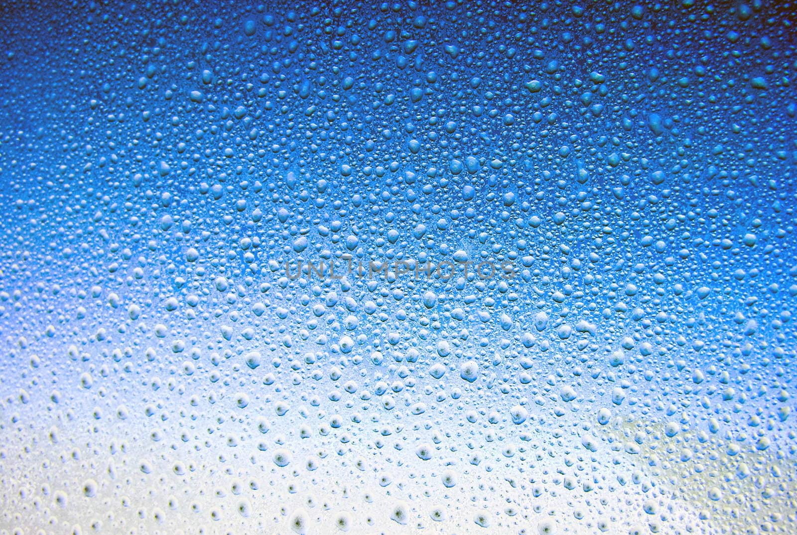 Water drop on a window in blue sky background 