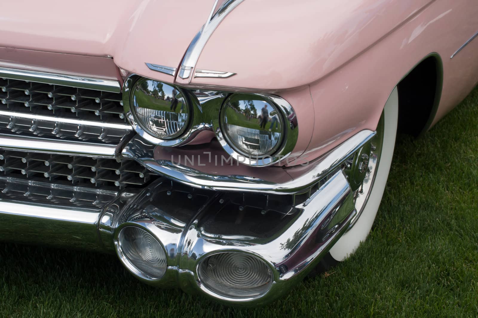 front of a pink classic car with headlight and fender