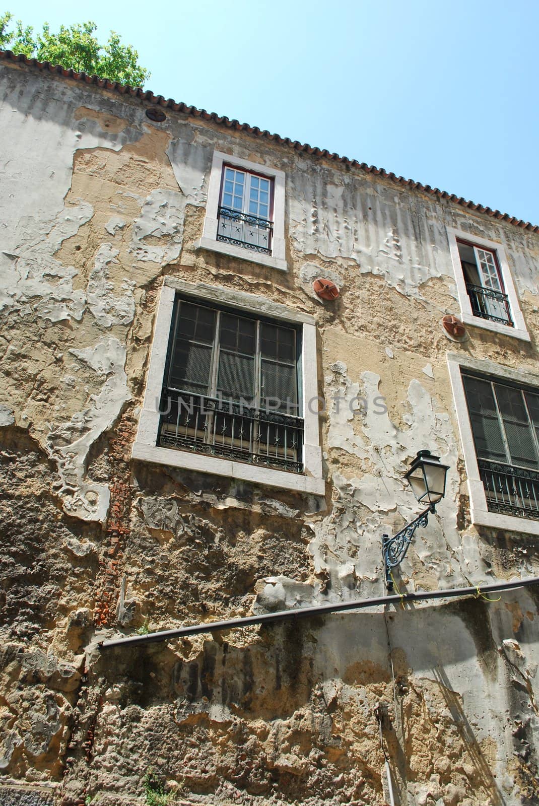 rusty building facade with antique lamp on the wall