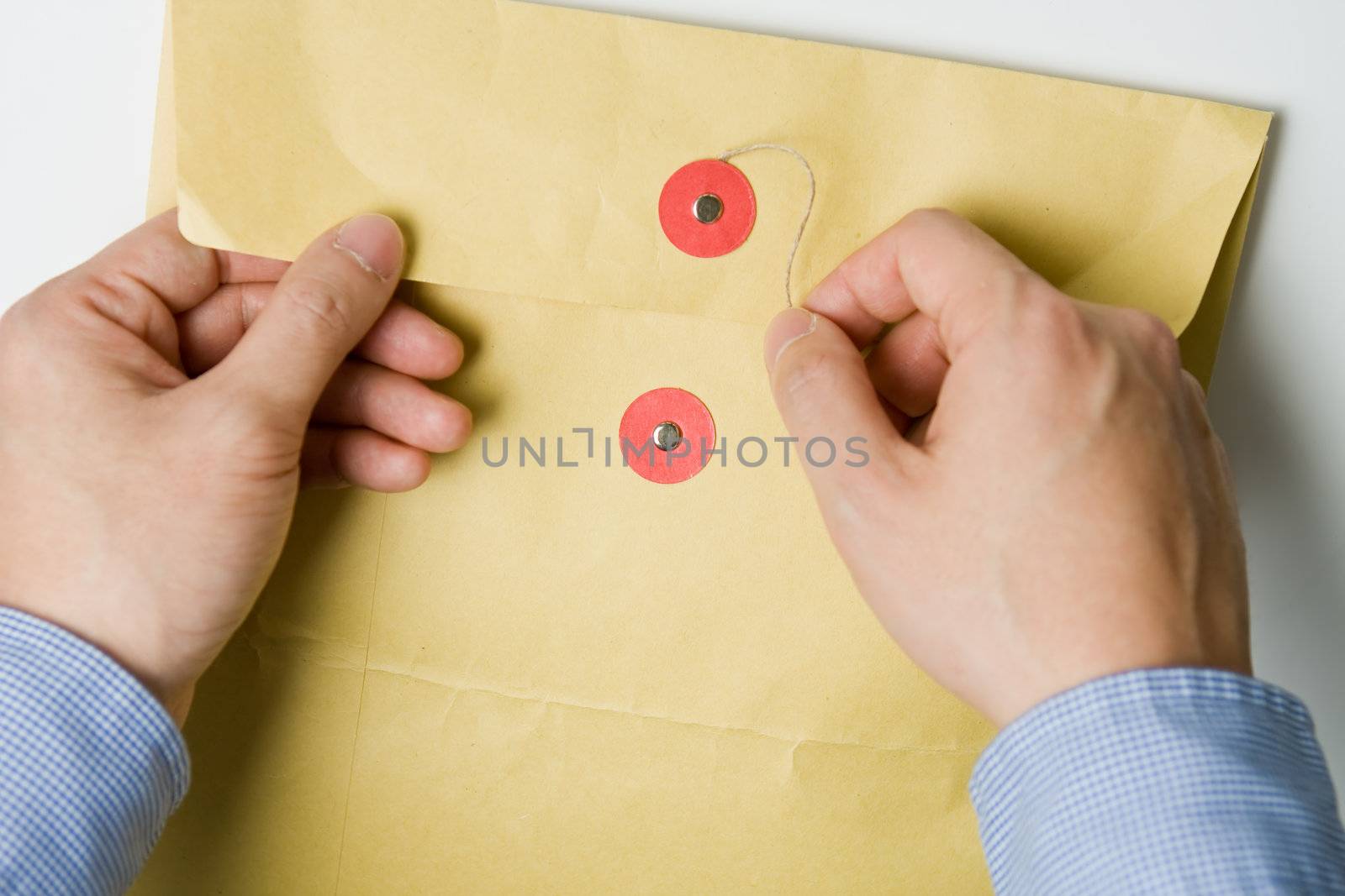 Person opening a confidential official document in an envelope