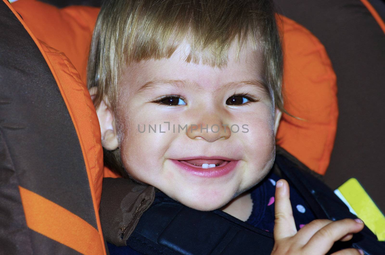 Baby smiling in child car seat. Shallow DOF.