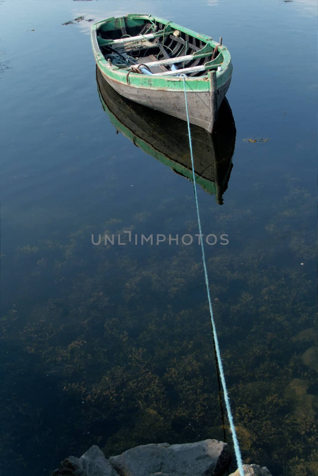 Small rowboat on a lake tied to the shore