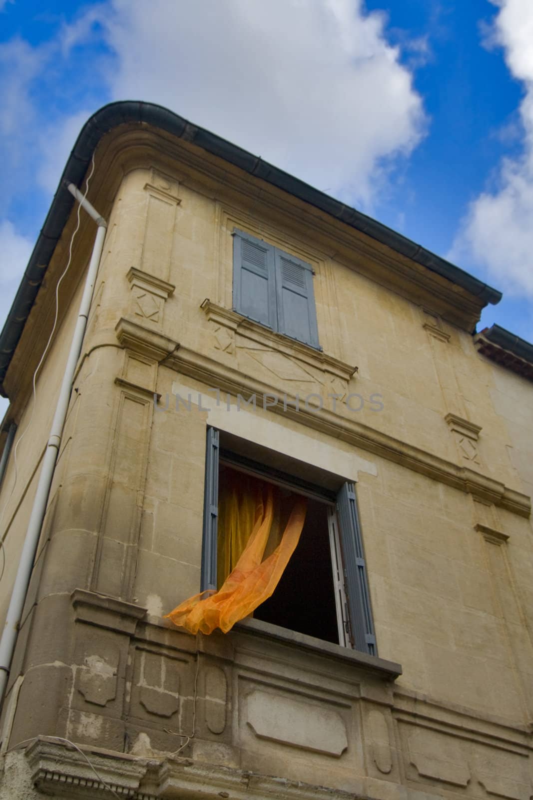 Open window with orange valance  in stone house