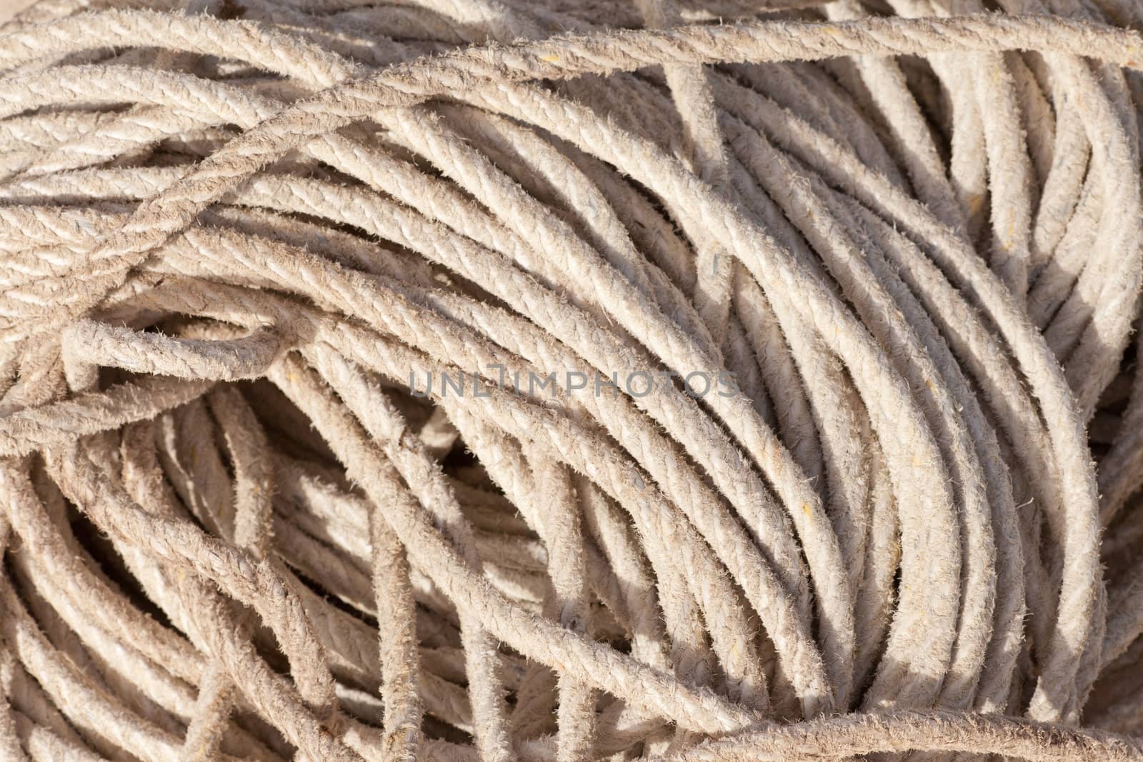 Old worn pile of hem rope coils background texture pattern.
