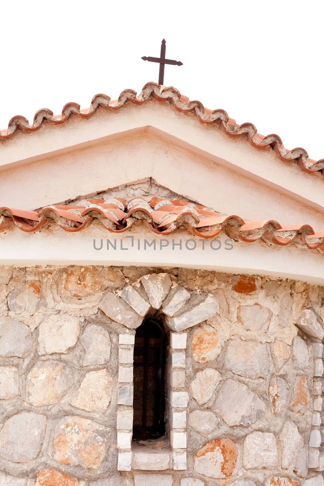 Roof top, wall and window of Greek-orthodox stone chapel.
