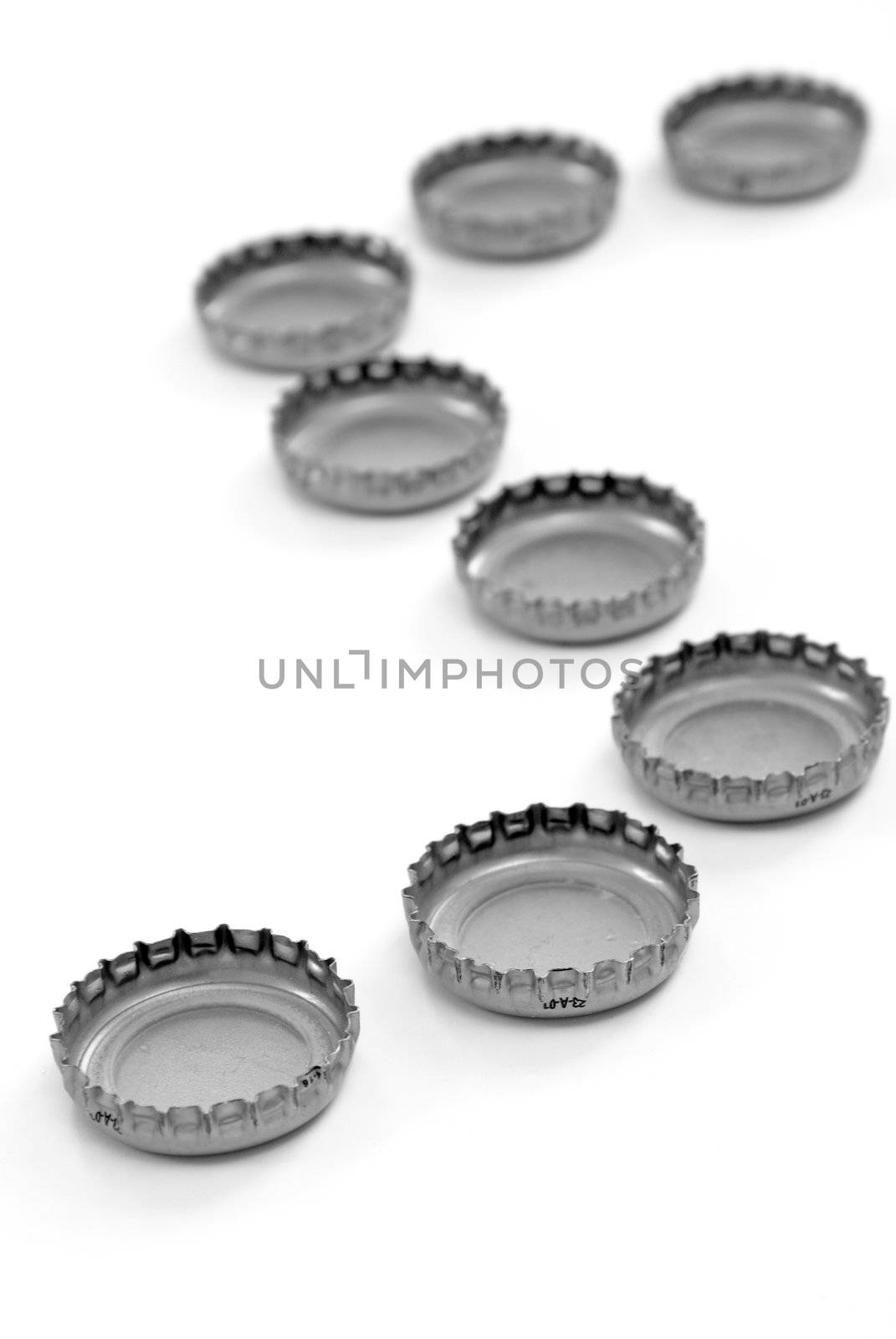 A line made of bottle caps, isolated on white.