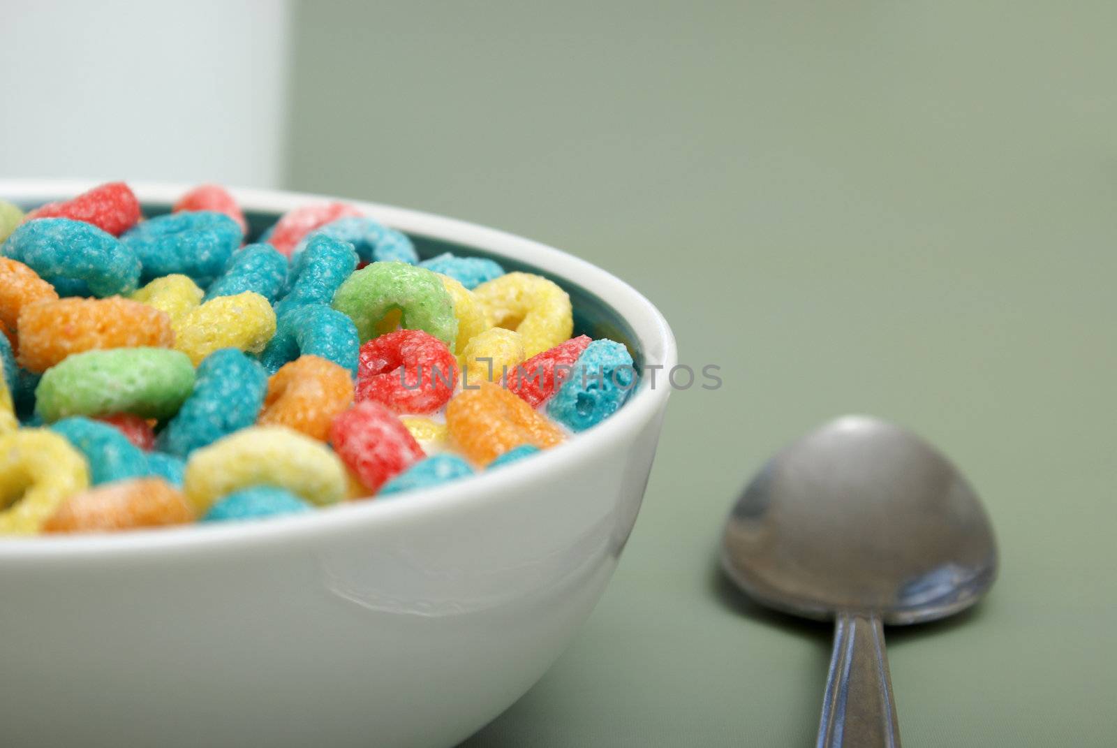 A bowl of fruit rings cereal with milk.