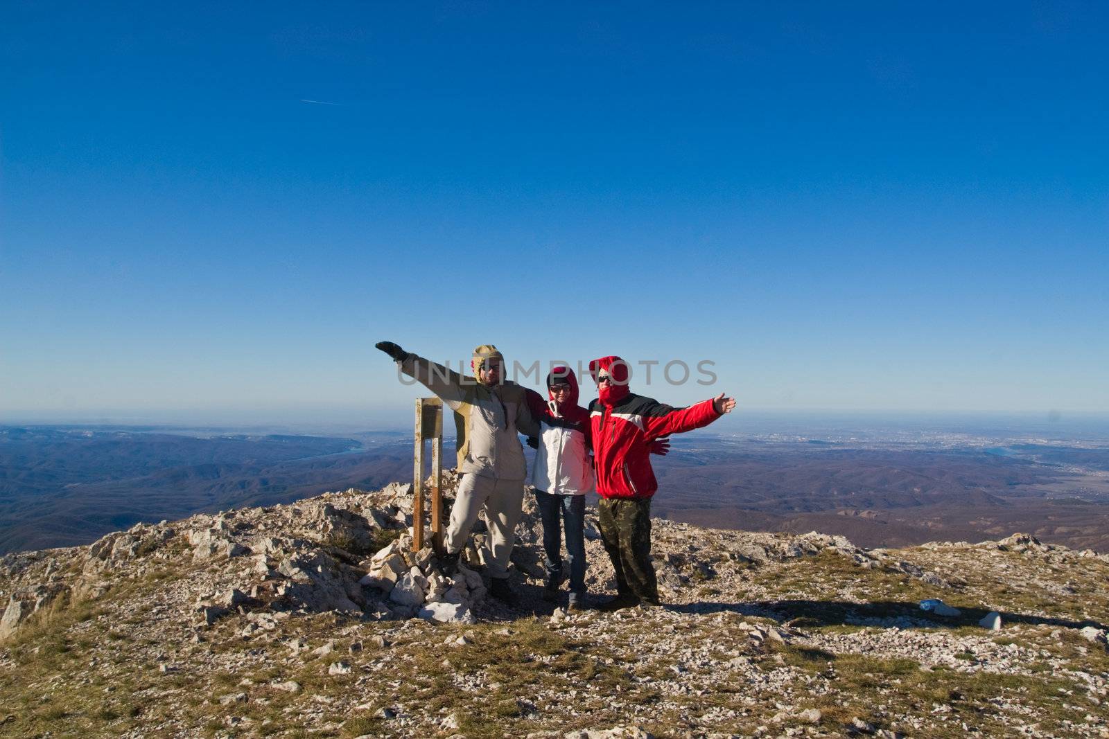 Happy hikers wave their hands  on mountain summit