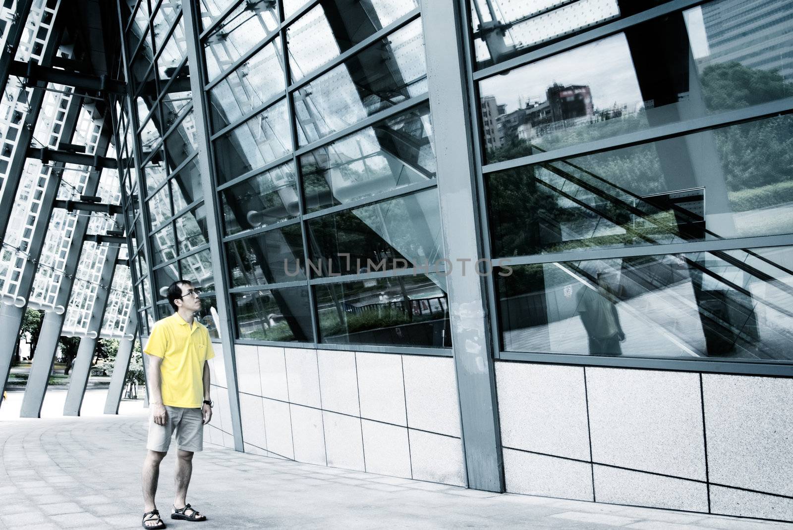 A man standing and watch the modern building.