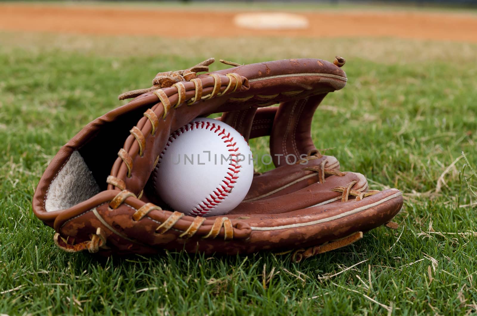 Baseball in Old Glove on Field by dehooks