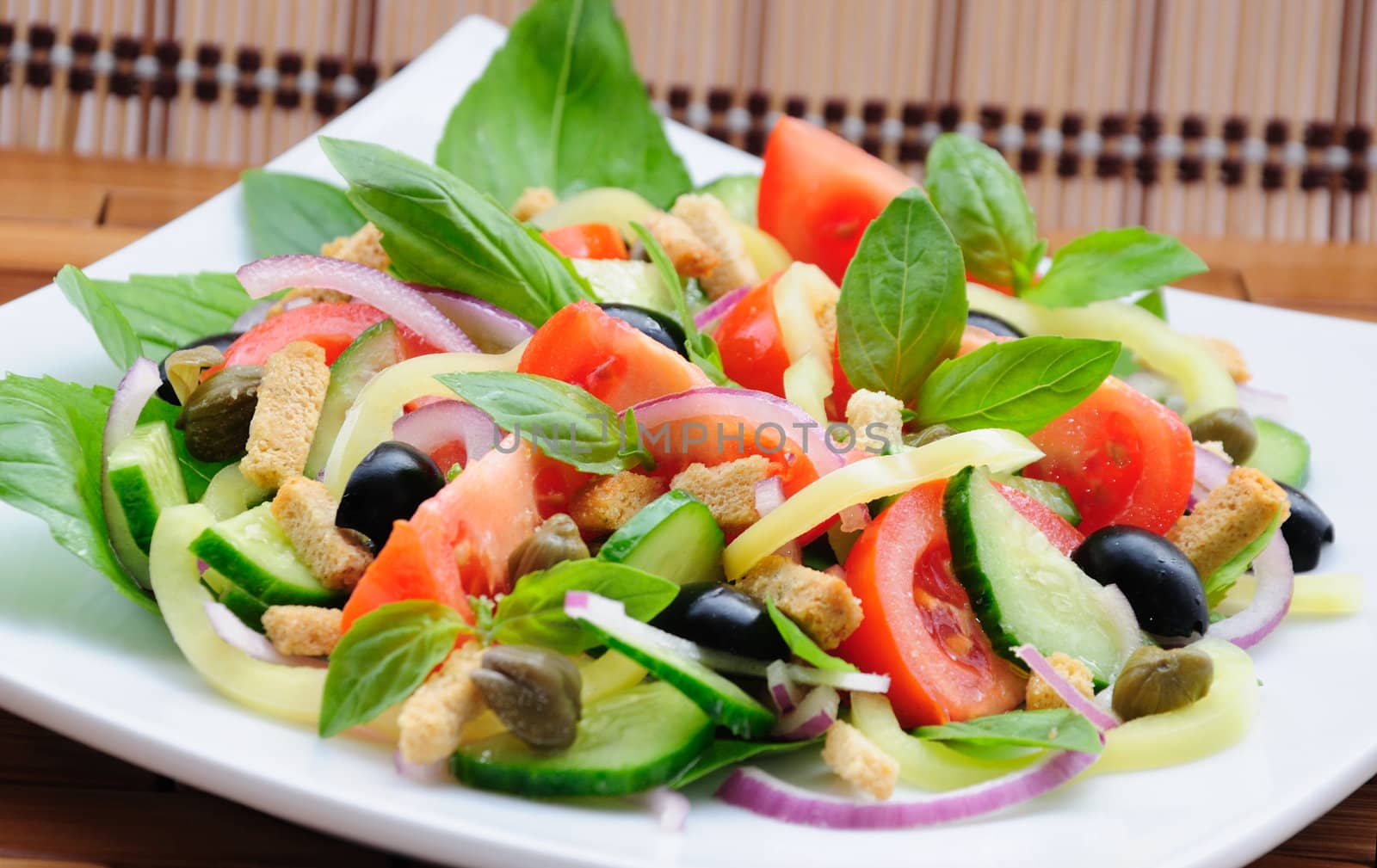 Fresh vegetable salad with basil, capers, olives, marinated with croutons