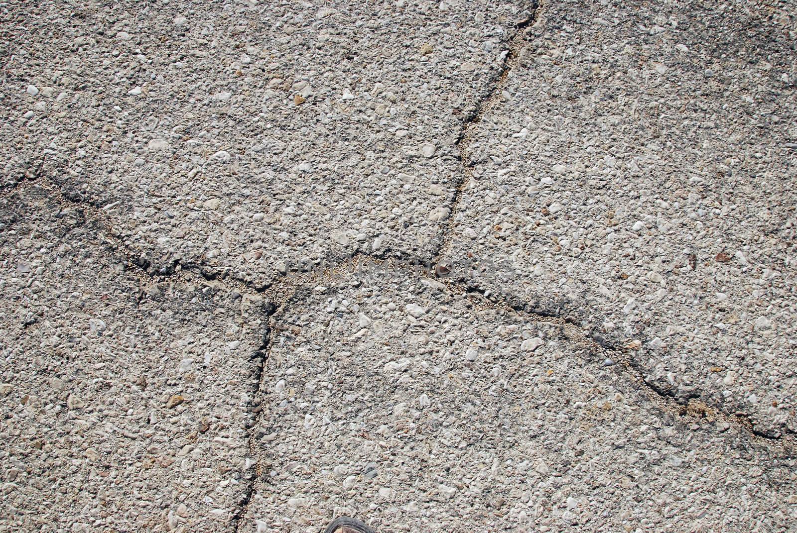 Fragment of old cracked asphalt road close up