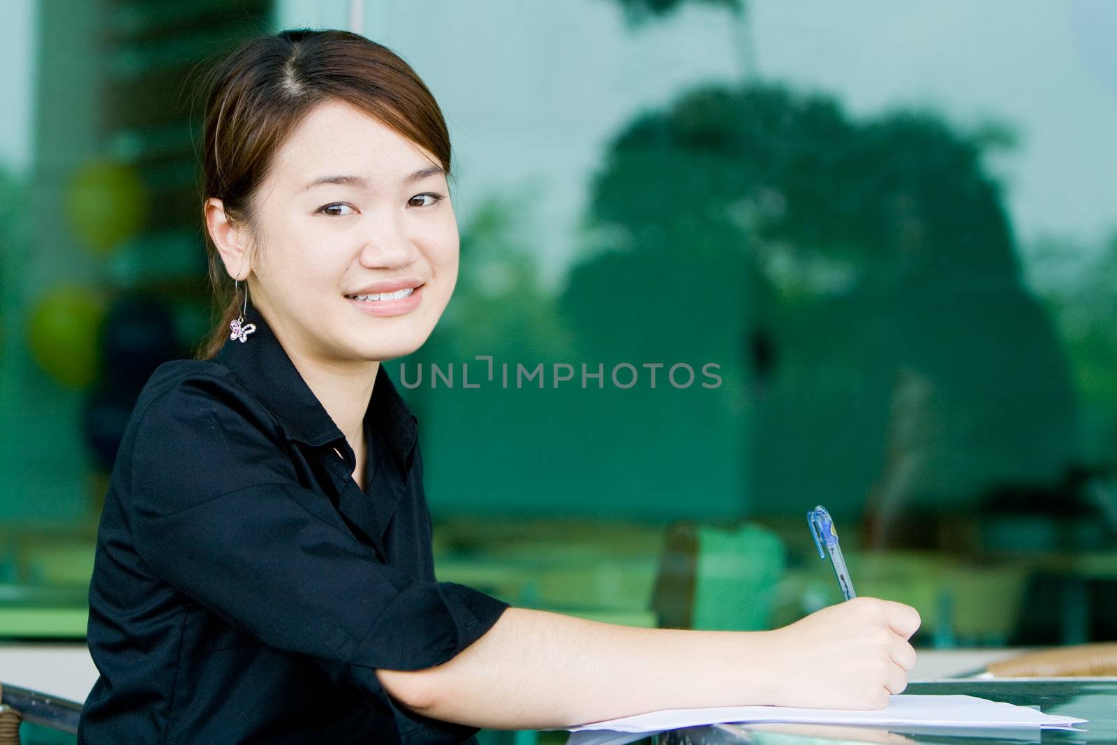 Young asian business woman working and writing her report in an office environment