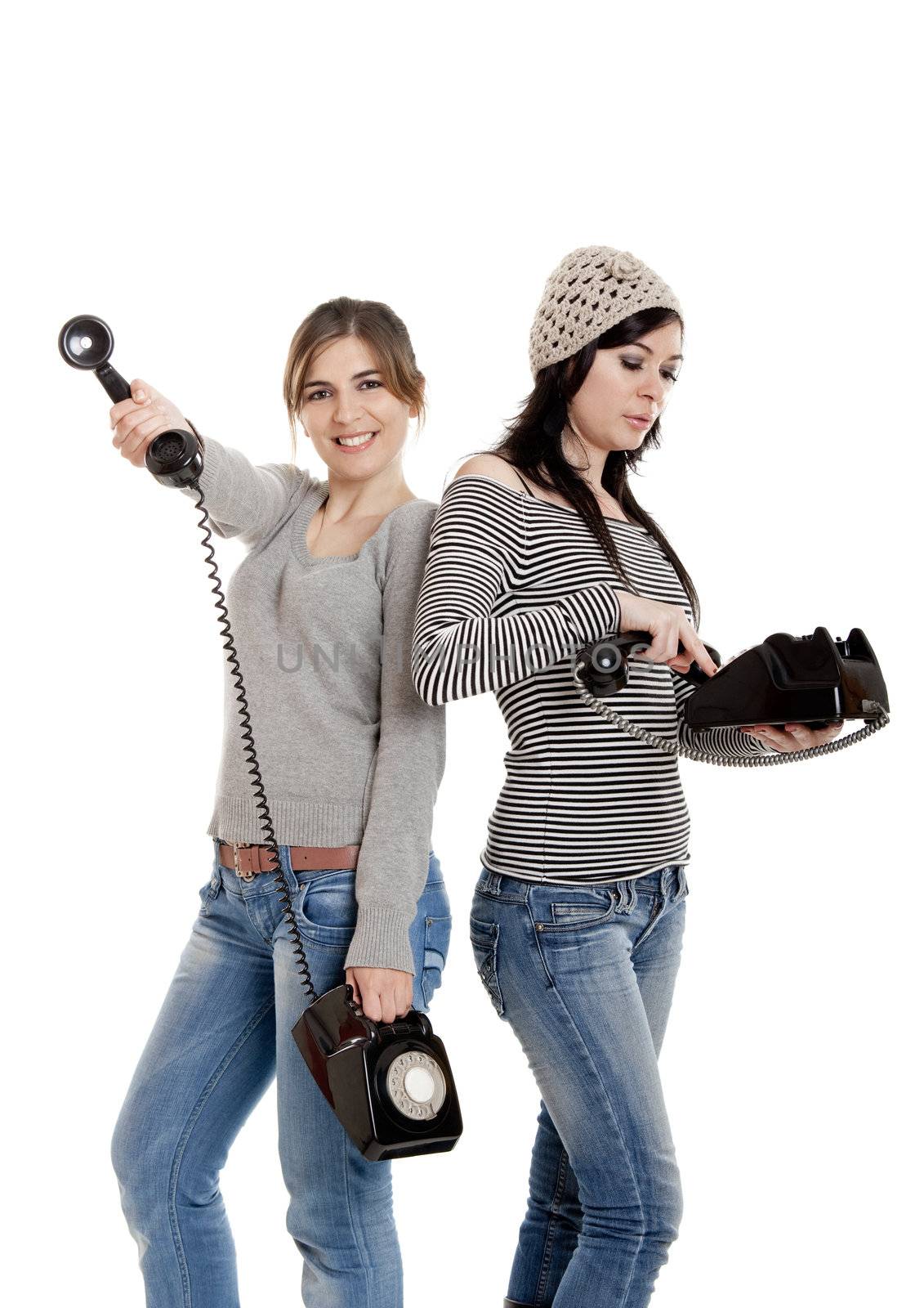 Two young women talking with old telephones - Isolated on white