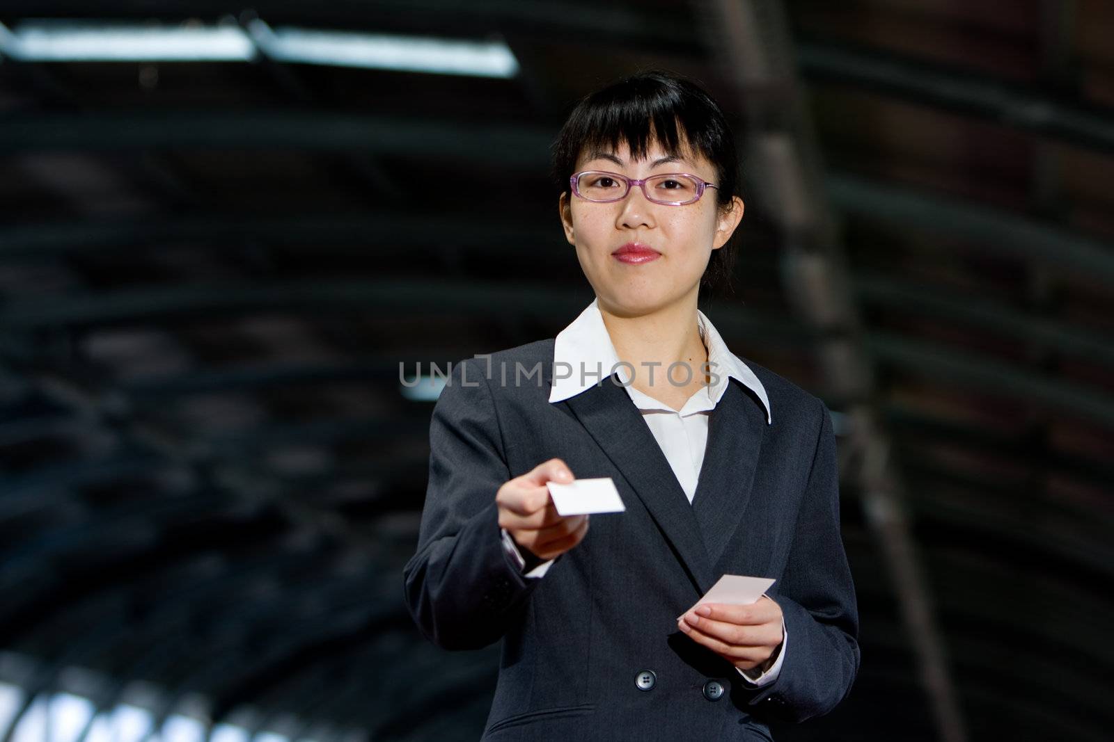 Asian woman giving her business calling card with a friendly smile