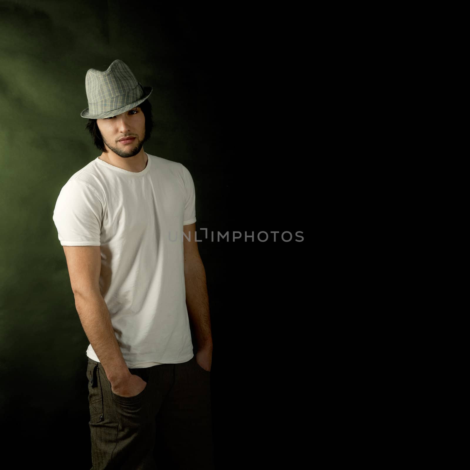 Young guy standing against a dark background
