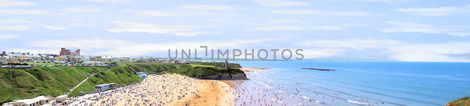 ballybunion and beach crowded with people by the cliffs on a hot day