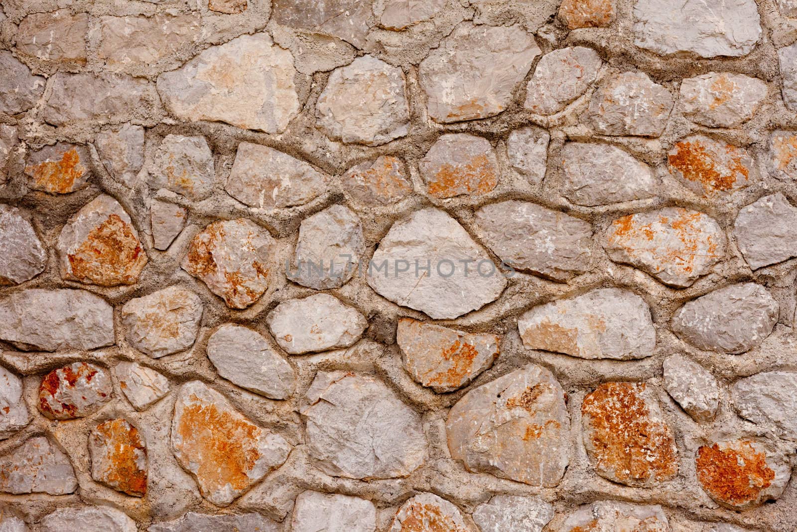 Rough quarry stone and mortar wall background texture pattern.