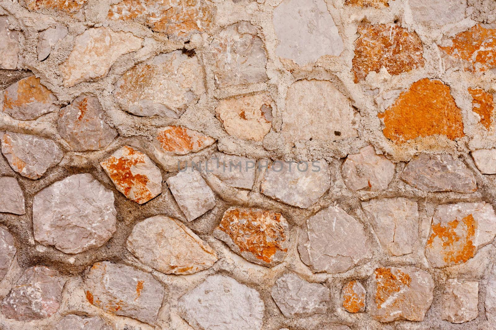 Rough quarry stone and mortar wall background texture pattern.