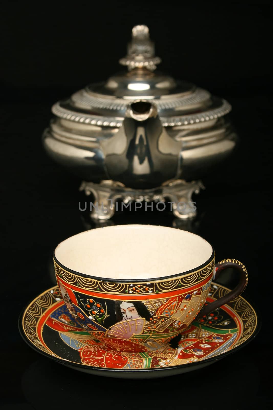 Silver teapot and an antique chinese cup of tea. More in gallery