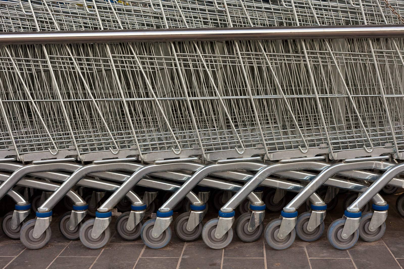 Detail of shiny metal shopping carts stacked in a row.