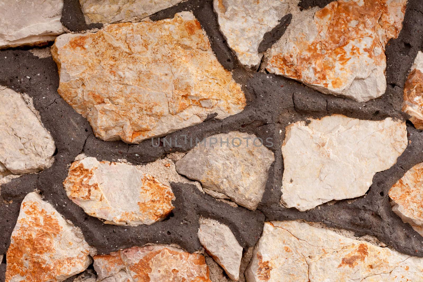 Rough quarry stone and mortar wall background texture pattern.