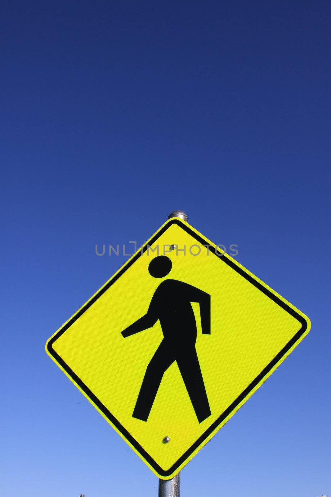 Road crossing sign over blue sky.