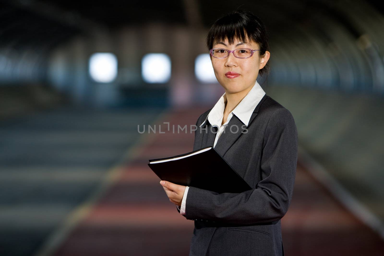 Young asian business woman standing holding journal or report