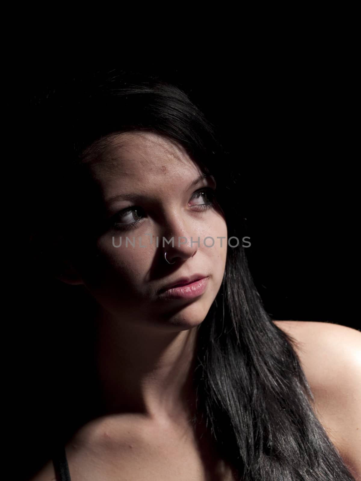 a teen girl with moody light on black