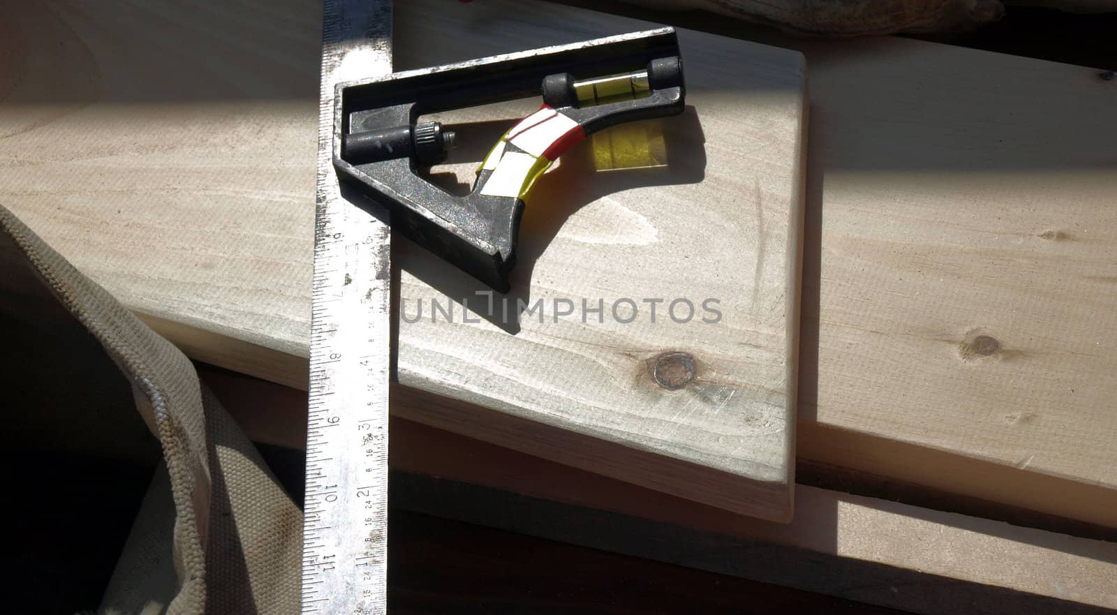 A metal ruler and level on a piece o wood