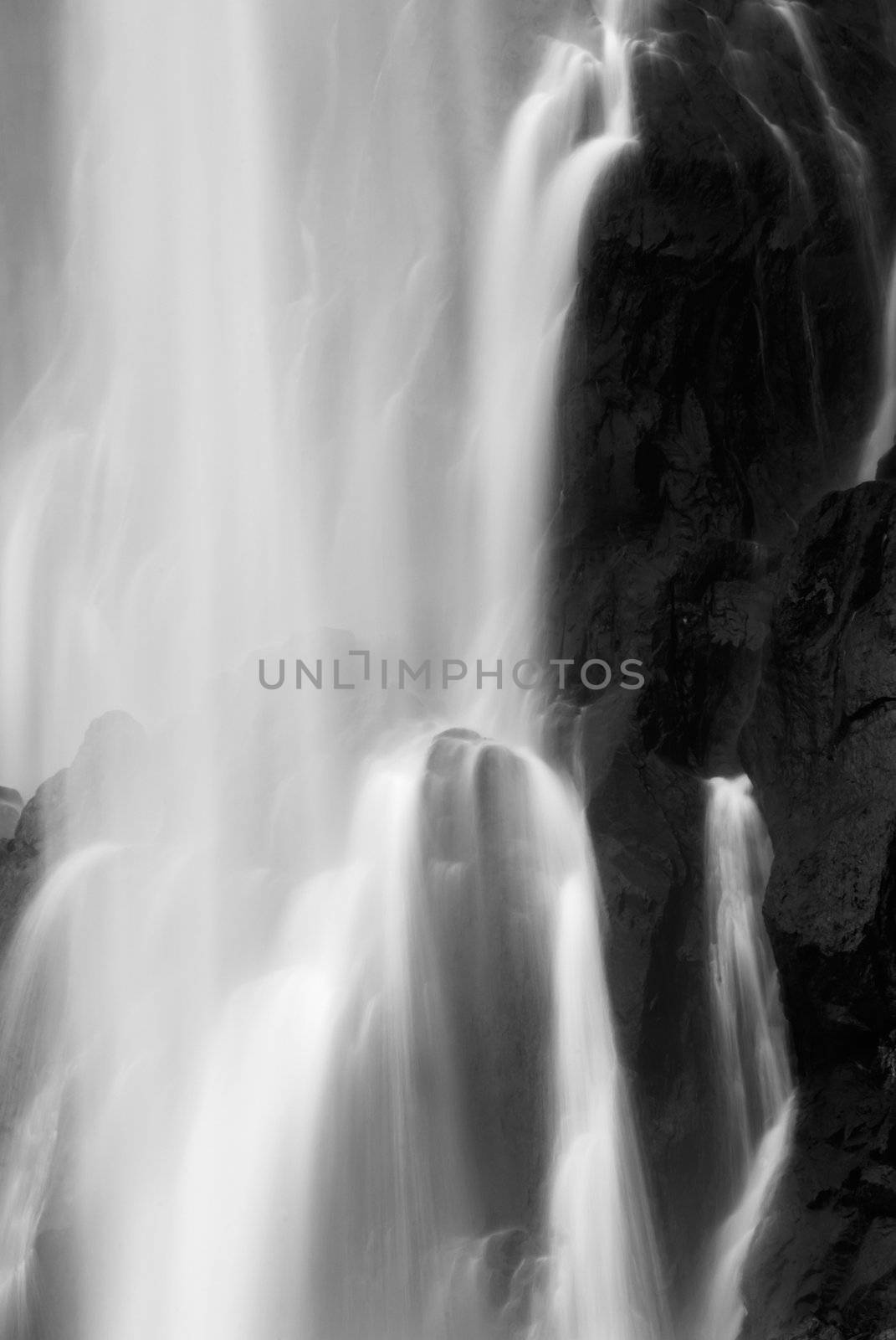 It is dramatic blurred view of waterfall flowing over rocks.