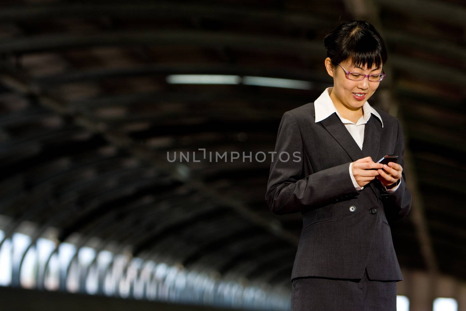 Asian business woman posing with mobile or hand phone, modern communication