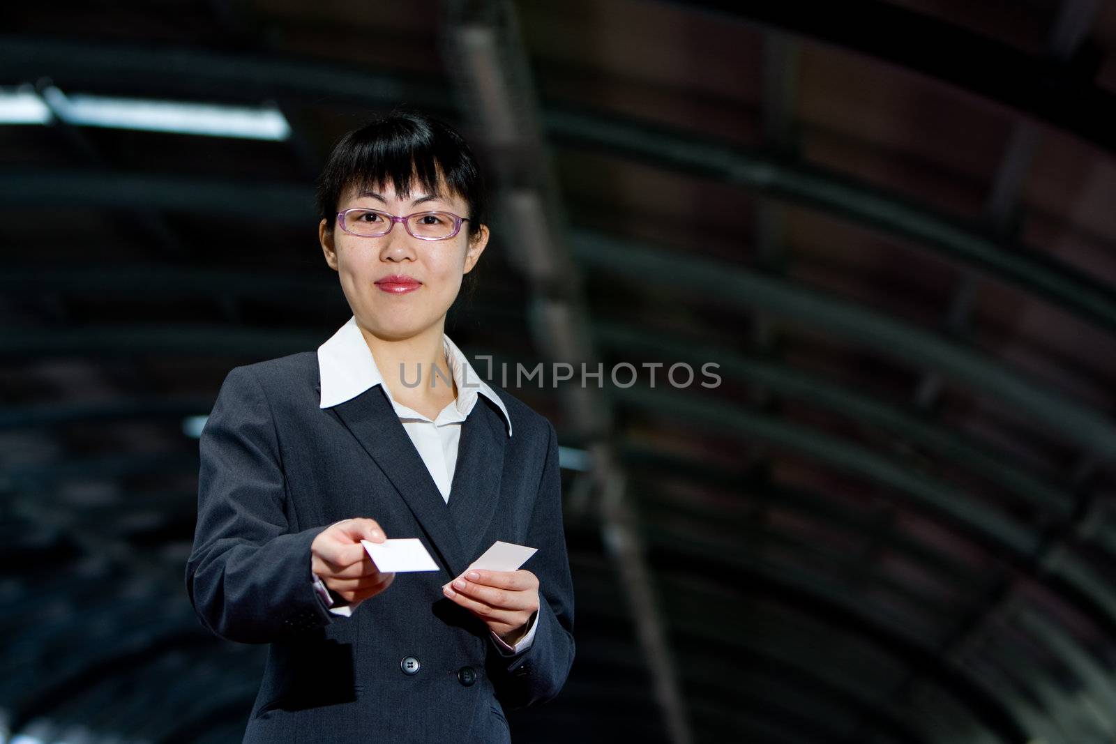 Asian woman giving her business calling card with a friendly smile