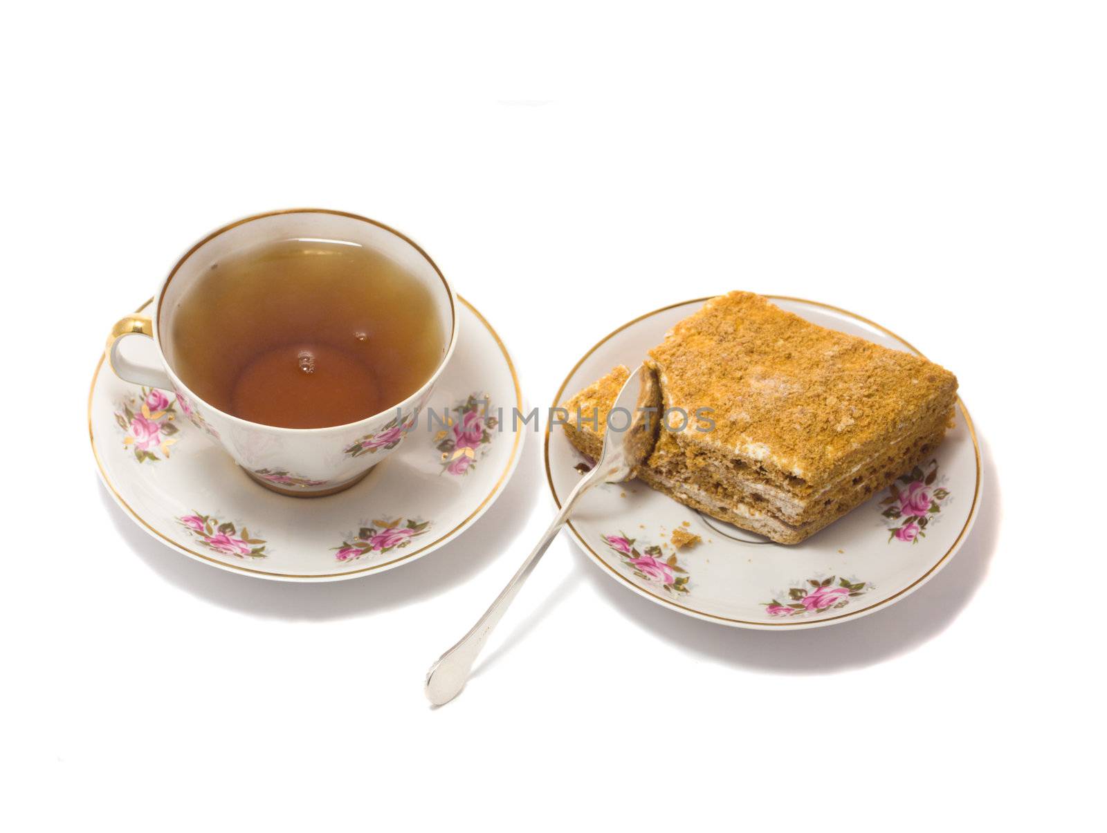 cup of tea with cake on plate, isolated on white