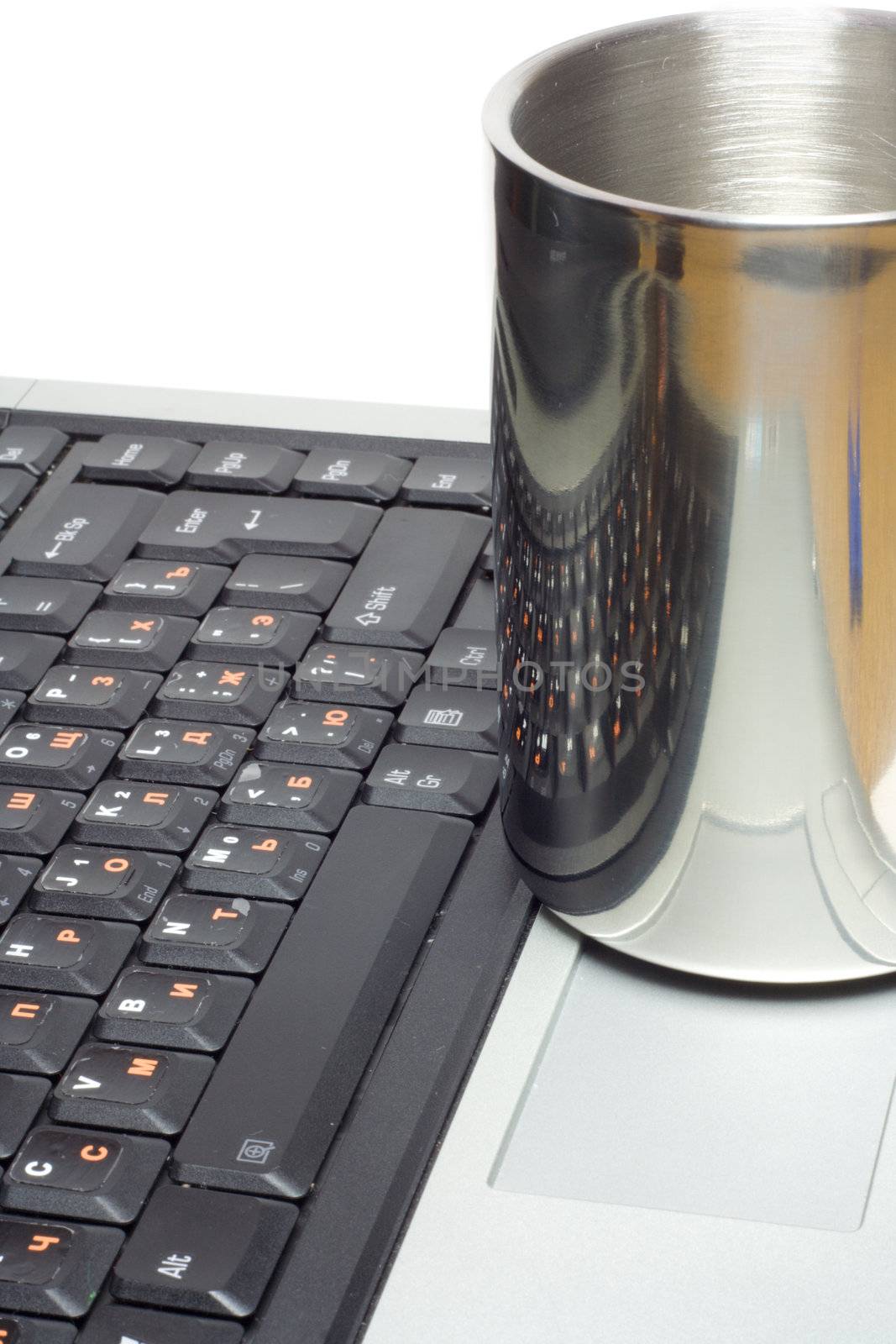 metal cup with keyboard reflection on laptop