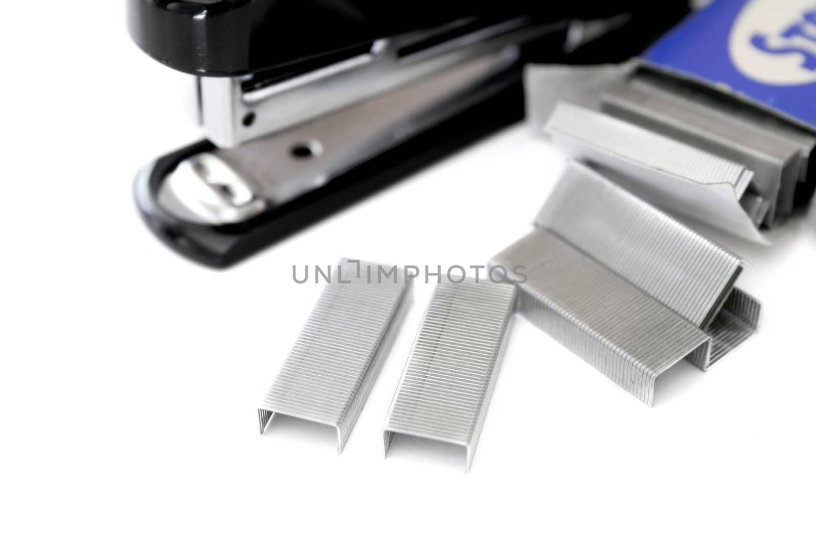 Staples and stapler isolated on a white background with a shallow DOF.