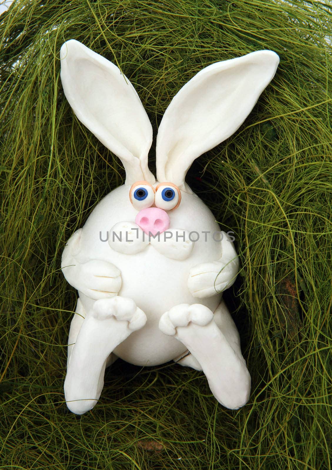The rabbit made of egg, lays in a nest from a grass
