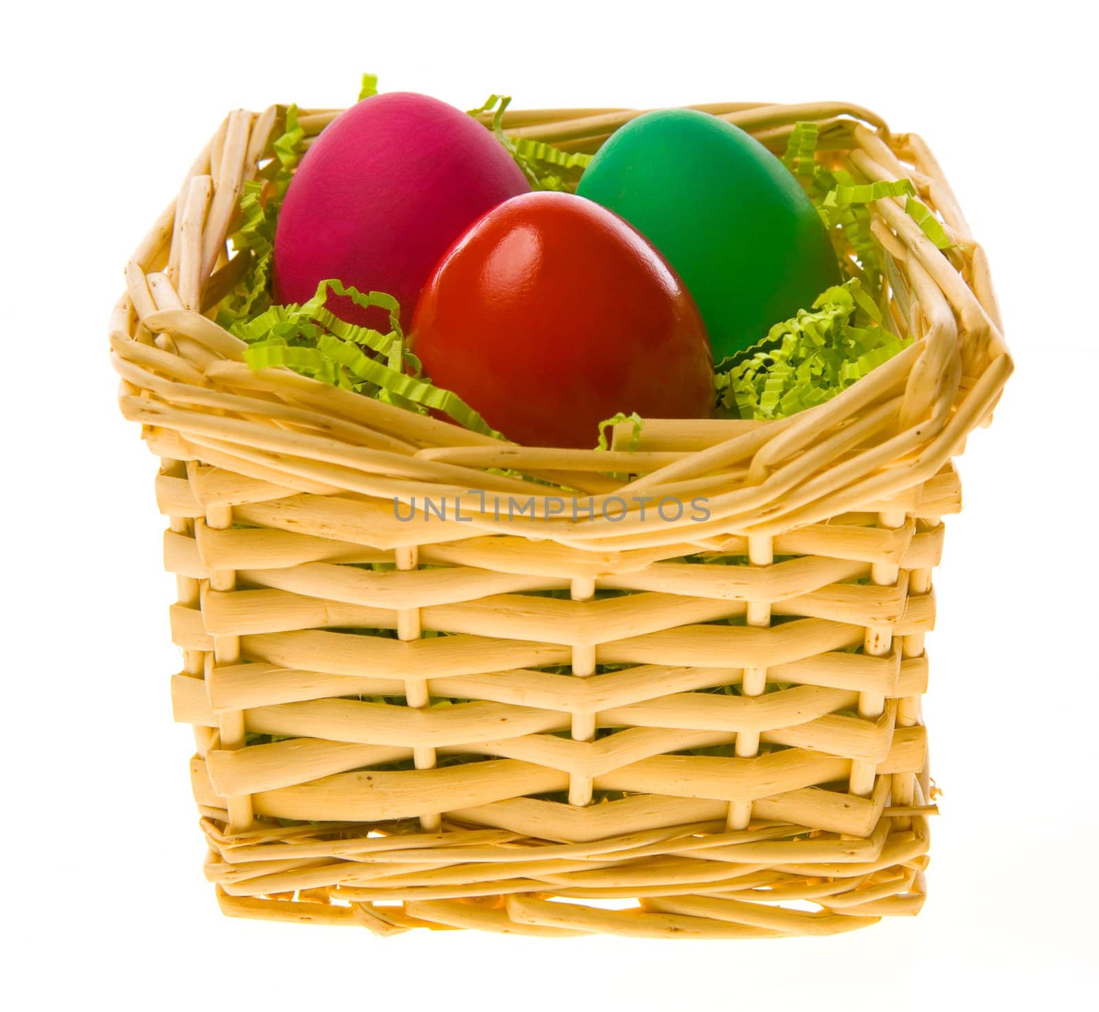 Three multi-coloured Easter eggs in a basket on a white background 
