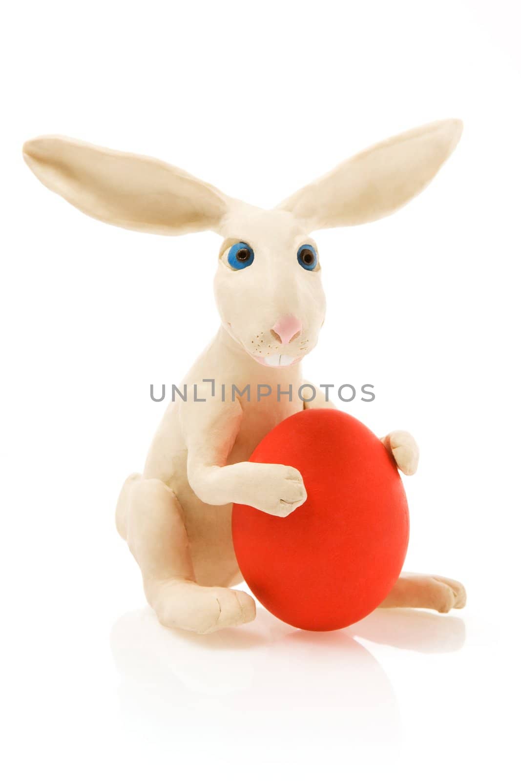  White toy rabbit with red egg.The image contains a path
