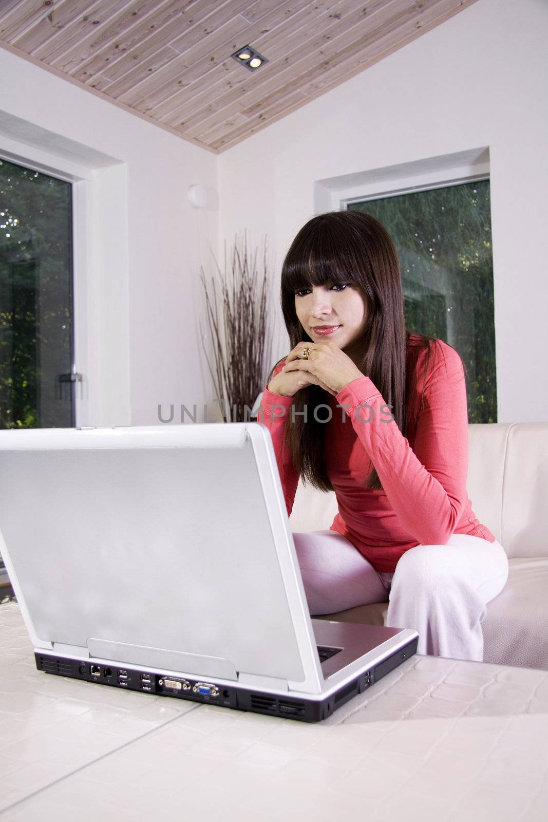 Woman sitting on a sofa using a laptop