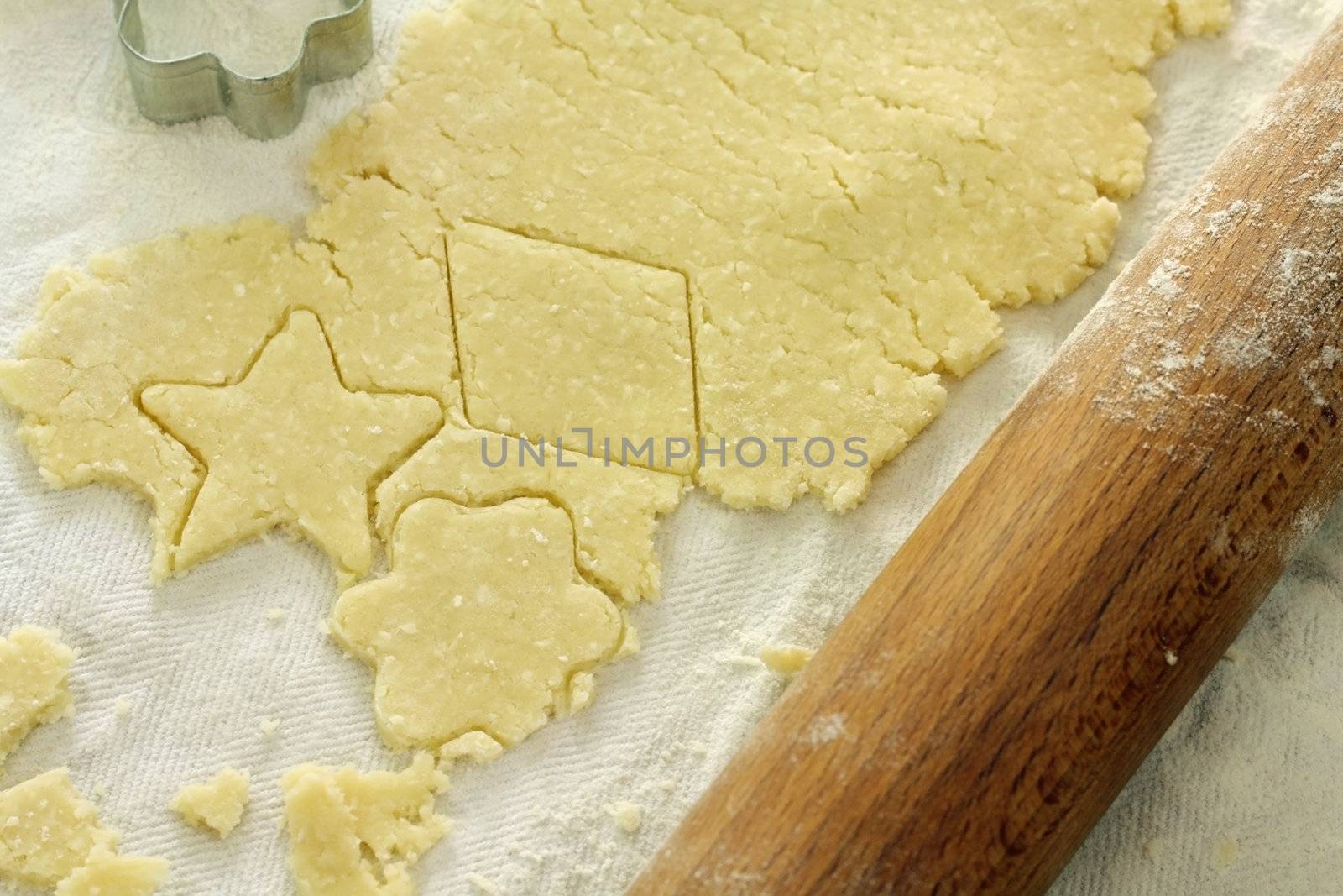 shaped cut dough near rolling pin and cutter on the table - shallow DOF