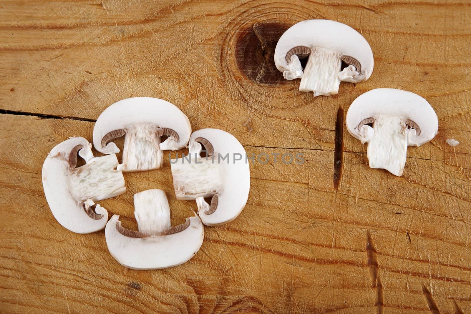 fresh champignon mushroom sliced on wooden background 