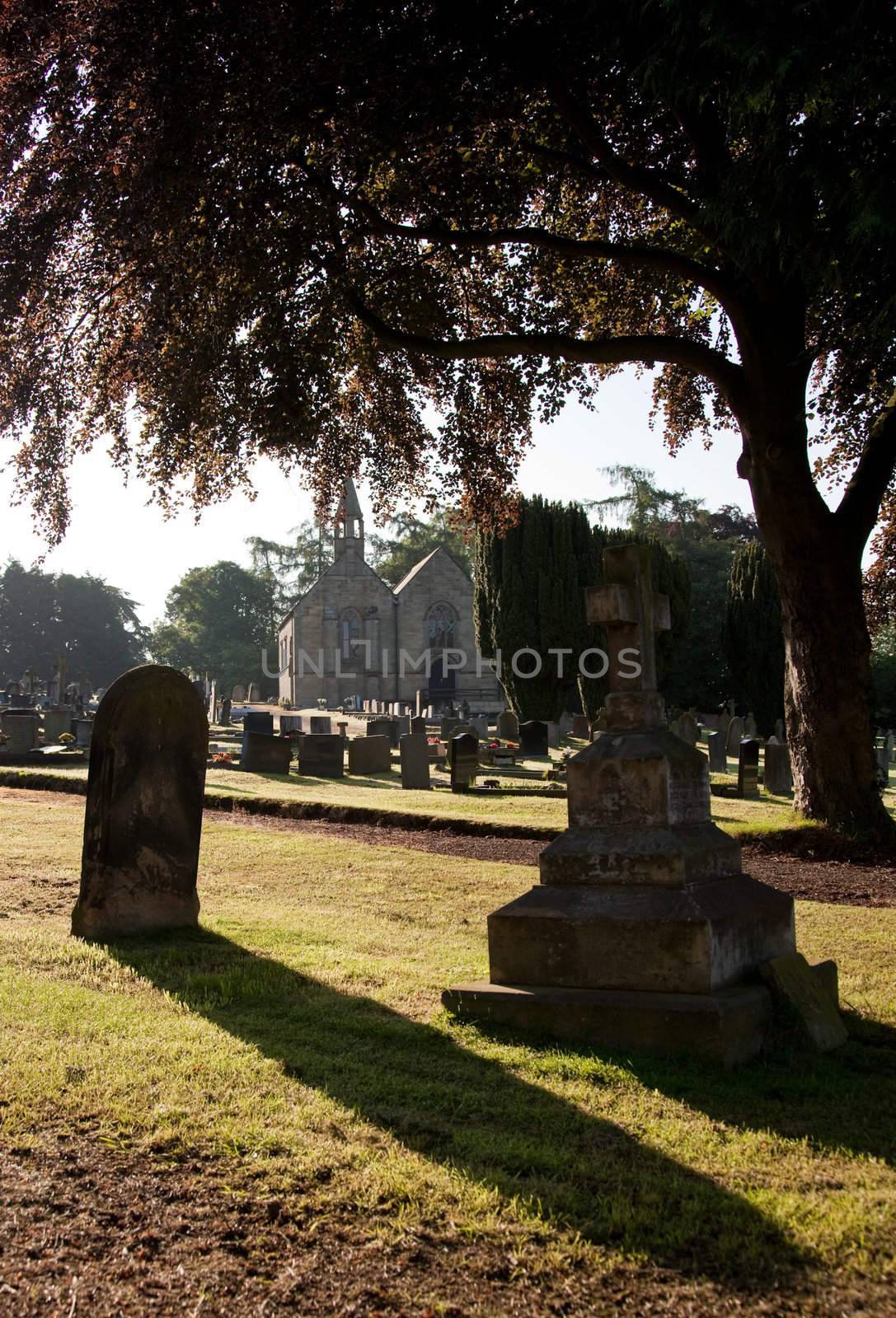 Early morning view of graveyard with distant church