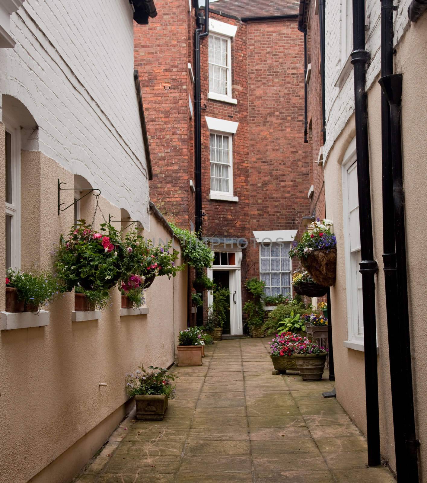 Flowering baskets lead to narrow alley in Shrewsbury