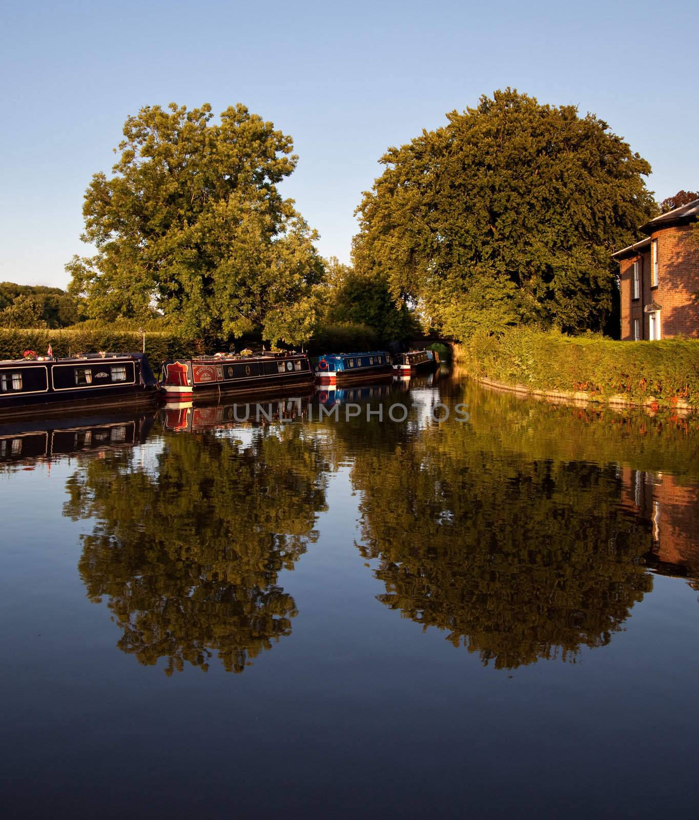 Canal barges reflected in the water by steheap